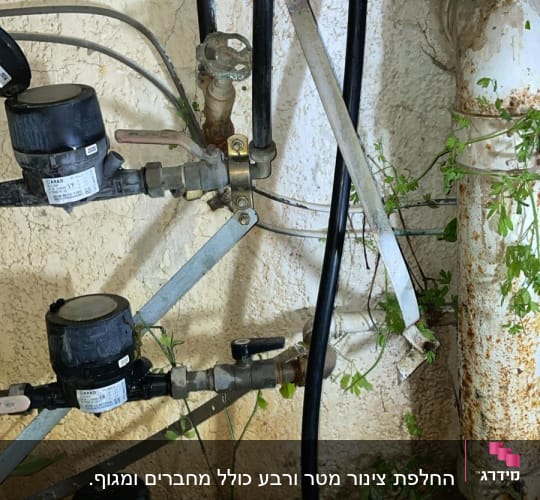 צינורות מים, ברזים ומדי מים מותקנים על קיר